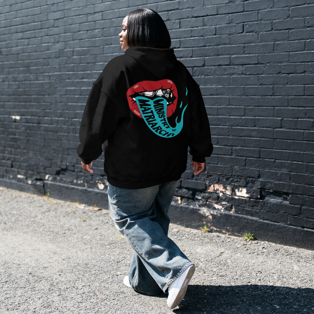 Ministry of Matriarchy hoodie in black worn by a model on the street, back view with red lips and snake tongue print