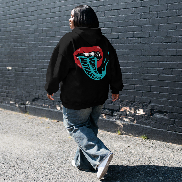 Ministry of Matriarchy hoodie in black worn by a model on the street, back view with red lips and snake tongue print