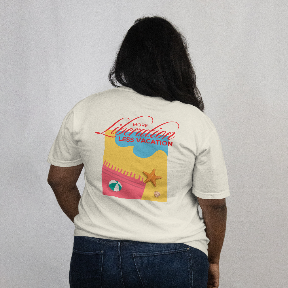 More Liberation, Less Vacation box tee in Vintage White worn by a model, back view with colourful beach graphic