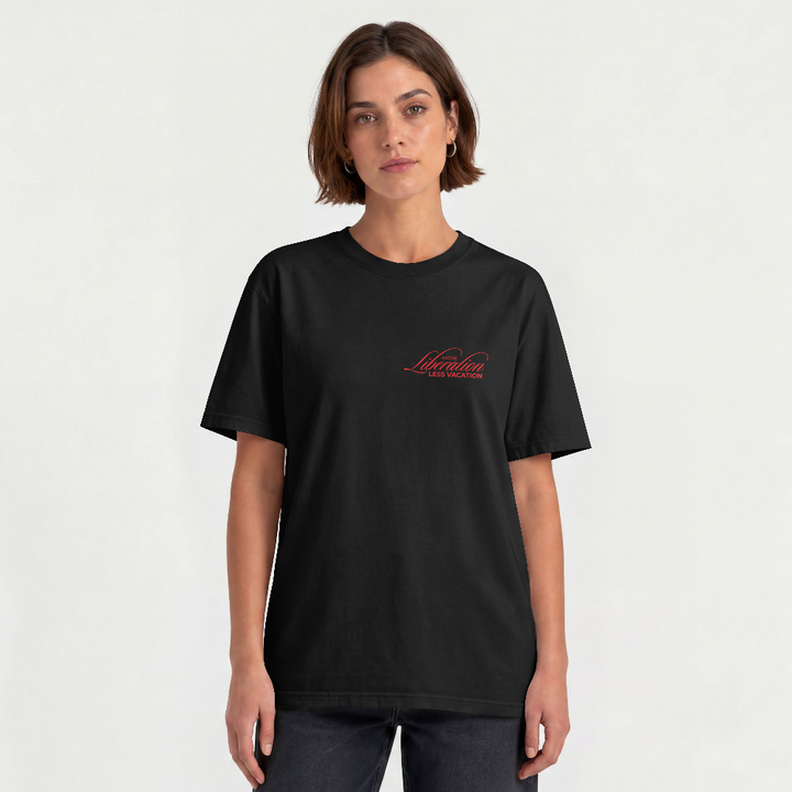 More Liberation, Less Vacation box tee in black worn by a model, front view with red script chest print