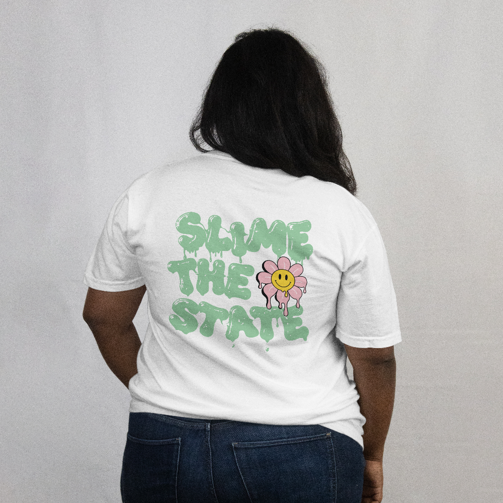 Slime the State box tee in white worn by a model, back view with green slime lettering and smiley flower